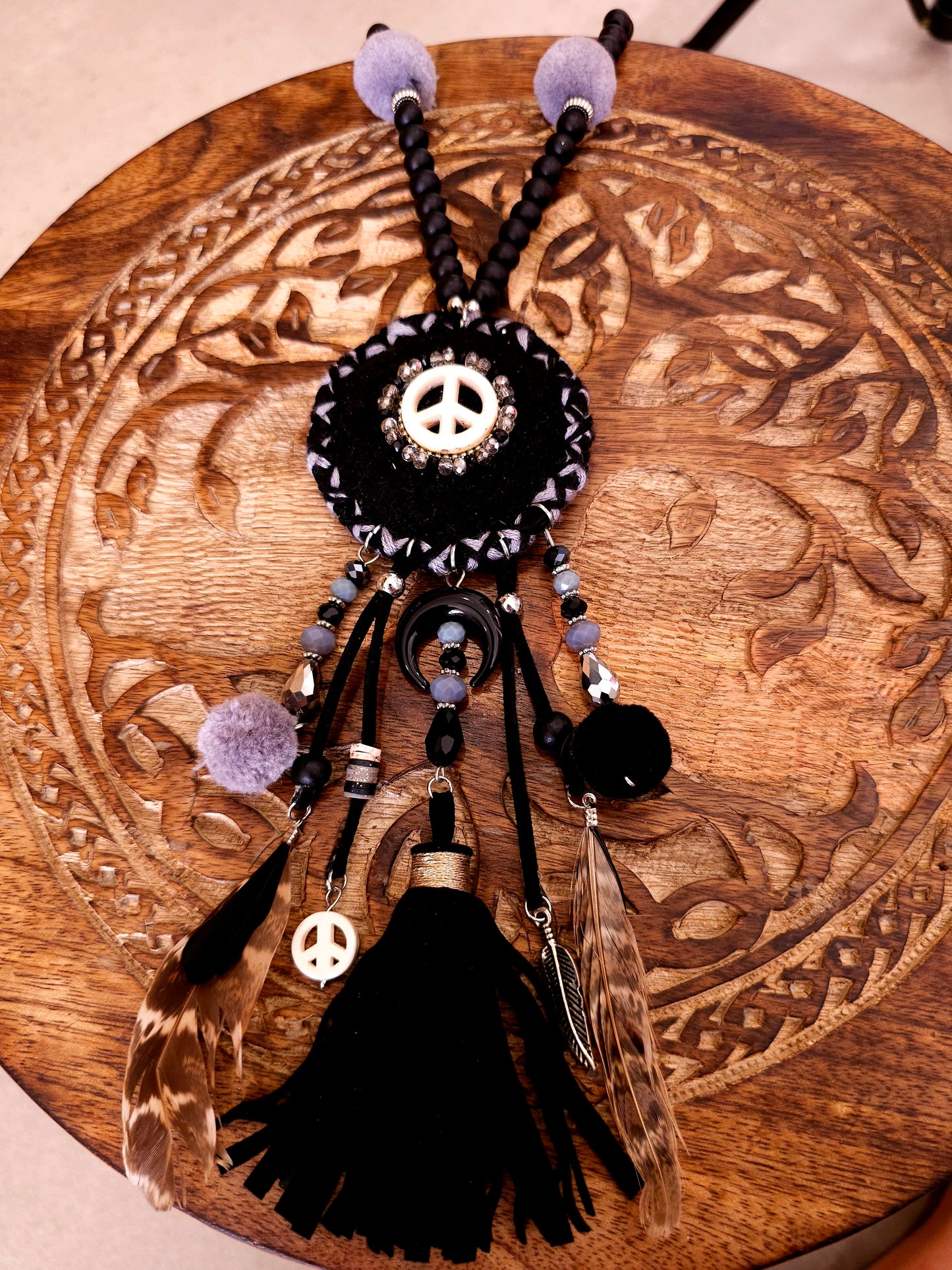Boho black necklace with peace symbol, beads, pom-poms, and tassels
