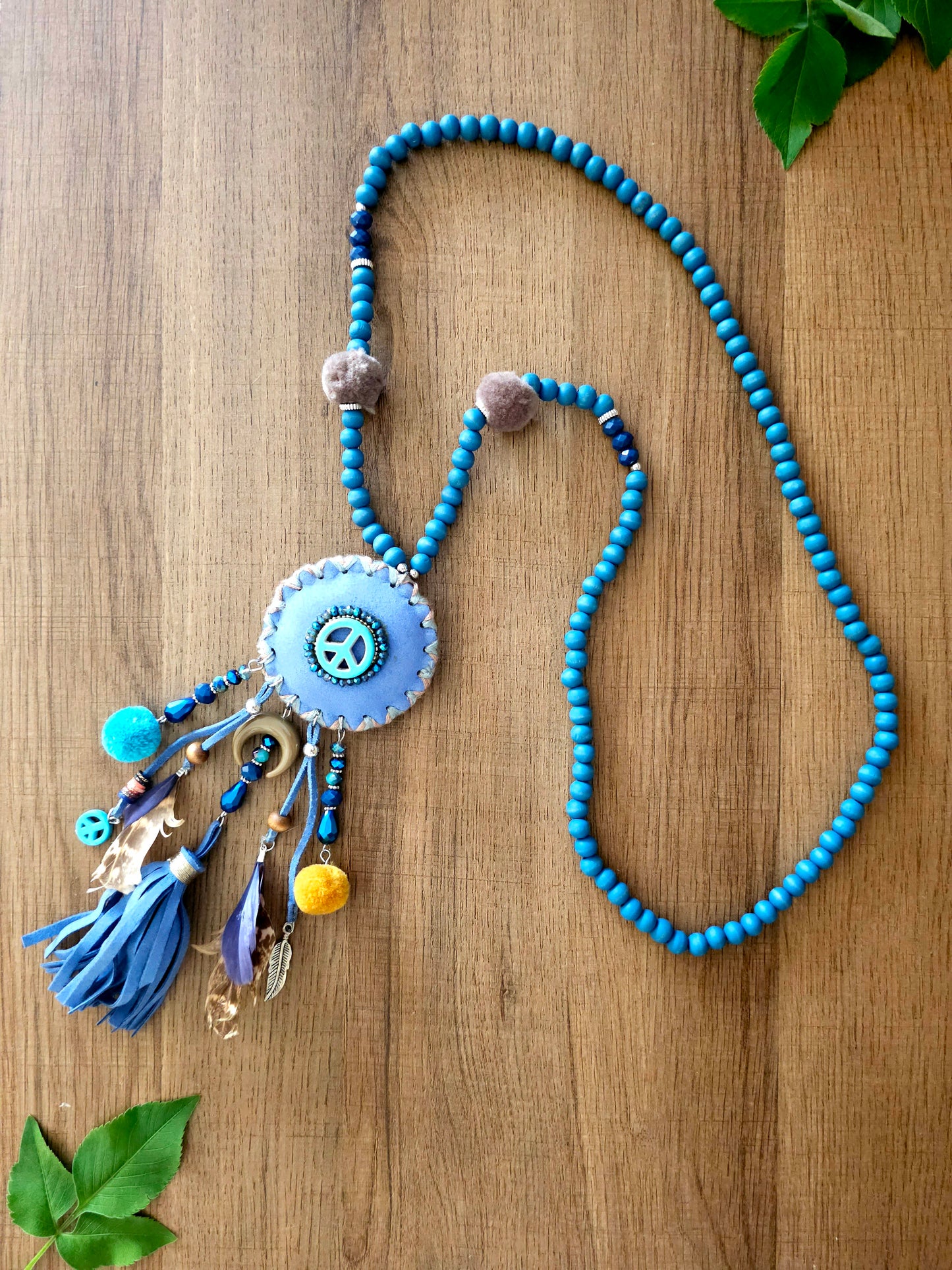 Boho peace necklace with tassels, feathers, and intricate beadwork