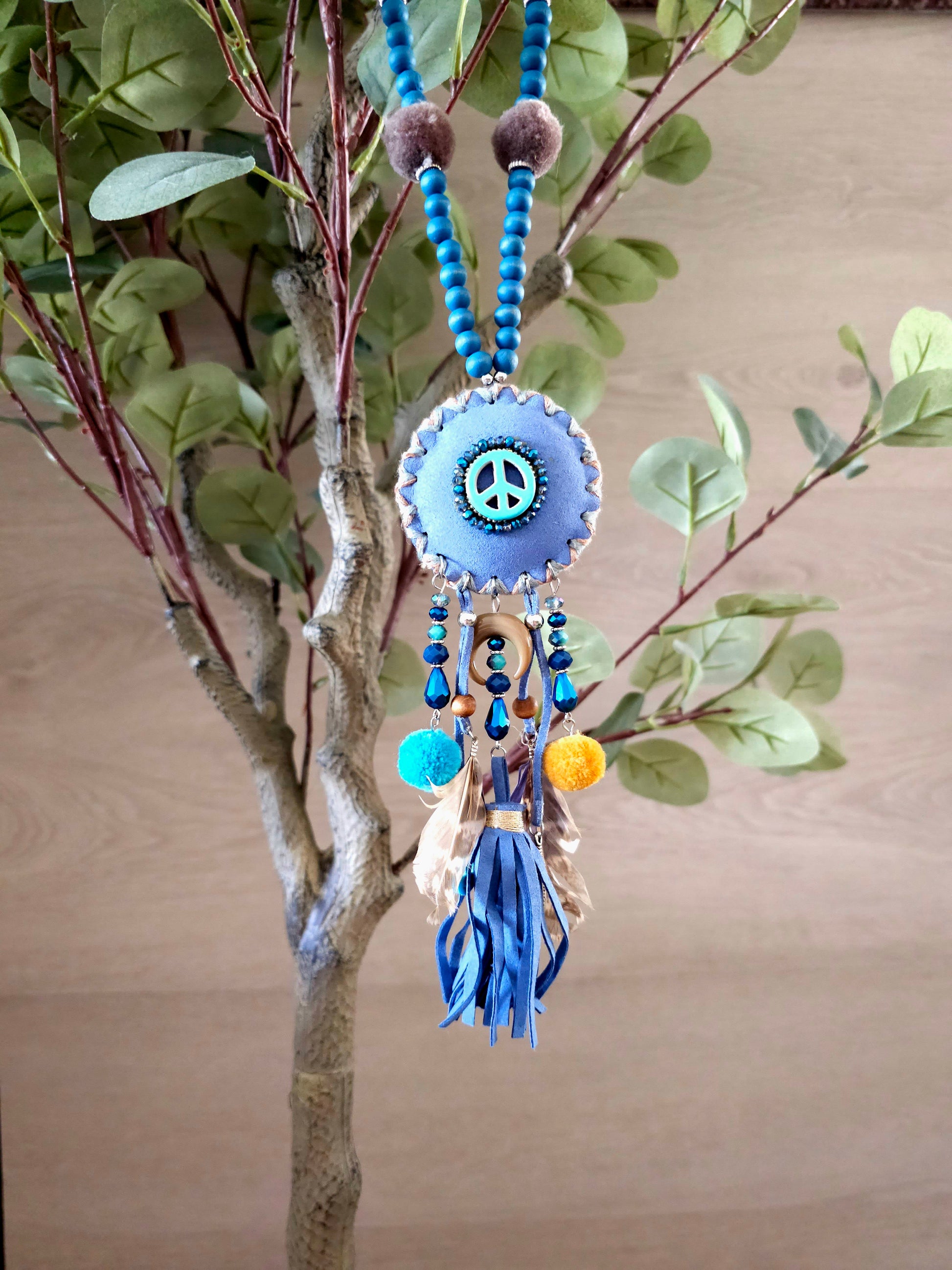 Boho peace necklace with tassels, feathers, and intricate beadwork