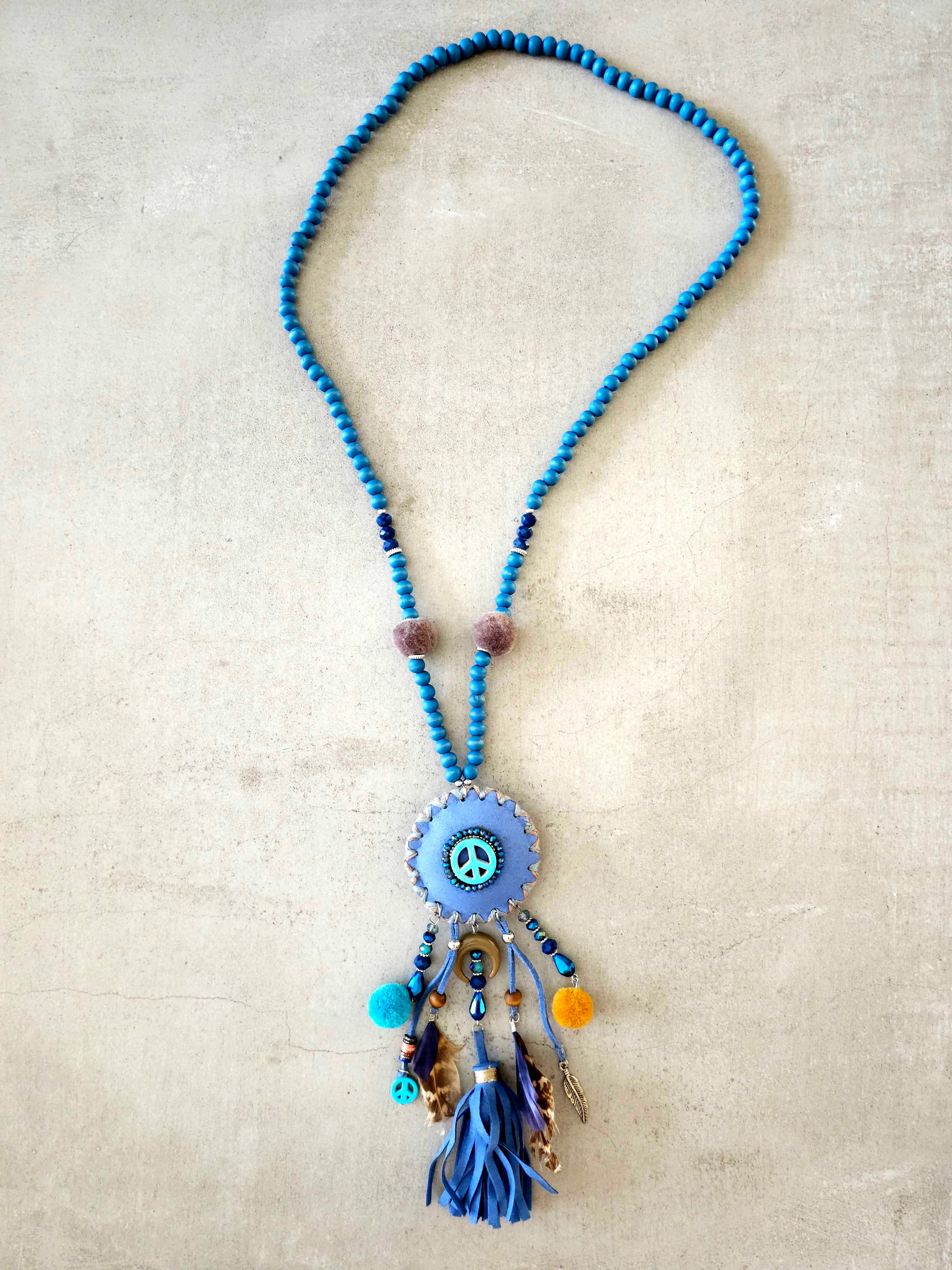 Boho peace necklace with tassels, feathers, and intricate beadwork