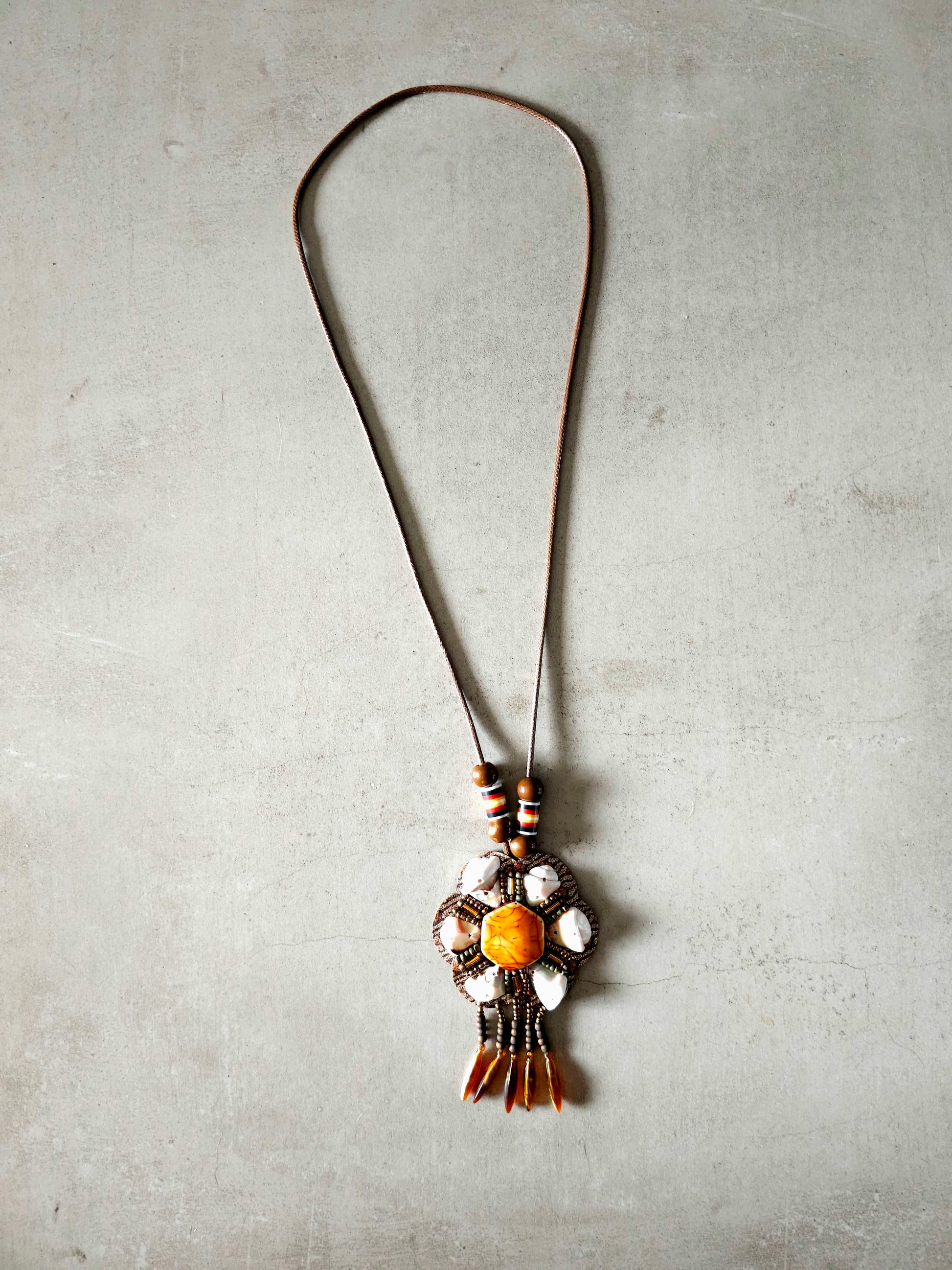 Boho amber pendant necklace with floral design and earthy beads