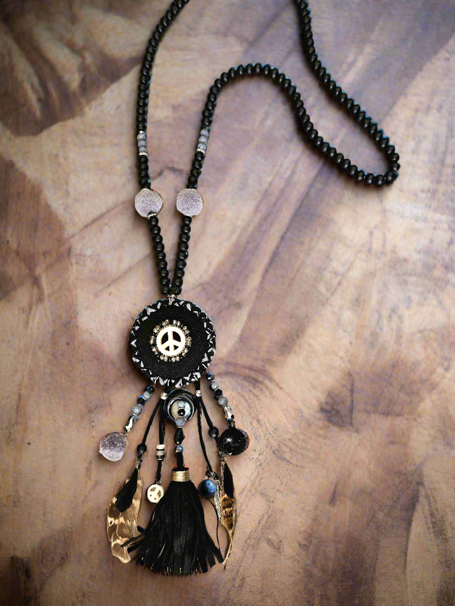 Boho black necklace with peace symbol, beads, pom-poms, and tassels