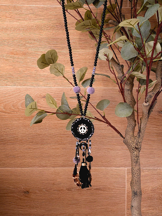 Boho black necklace with peace symbol, beads, pom-poms, and tassels